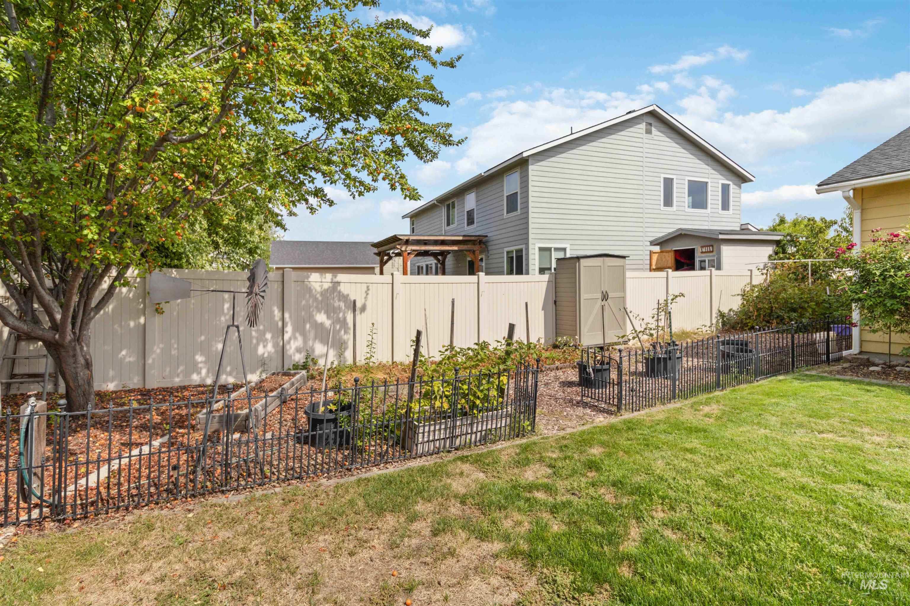 Fenced backyard with a storage shed and a garden