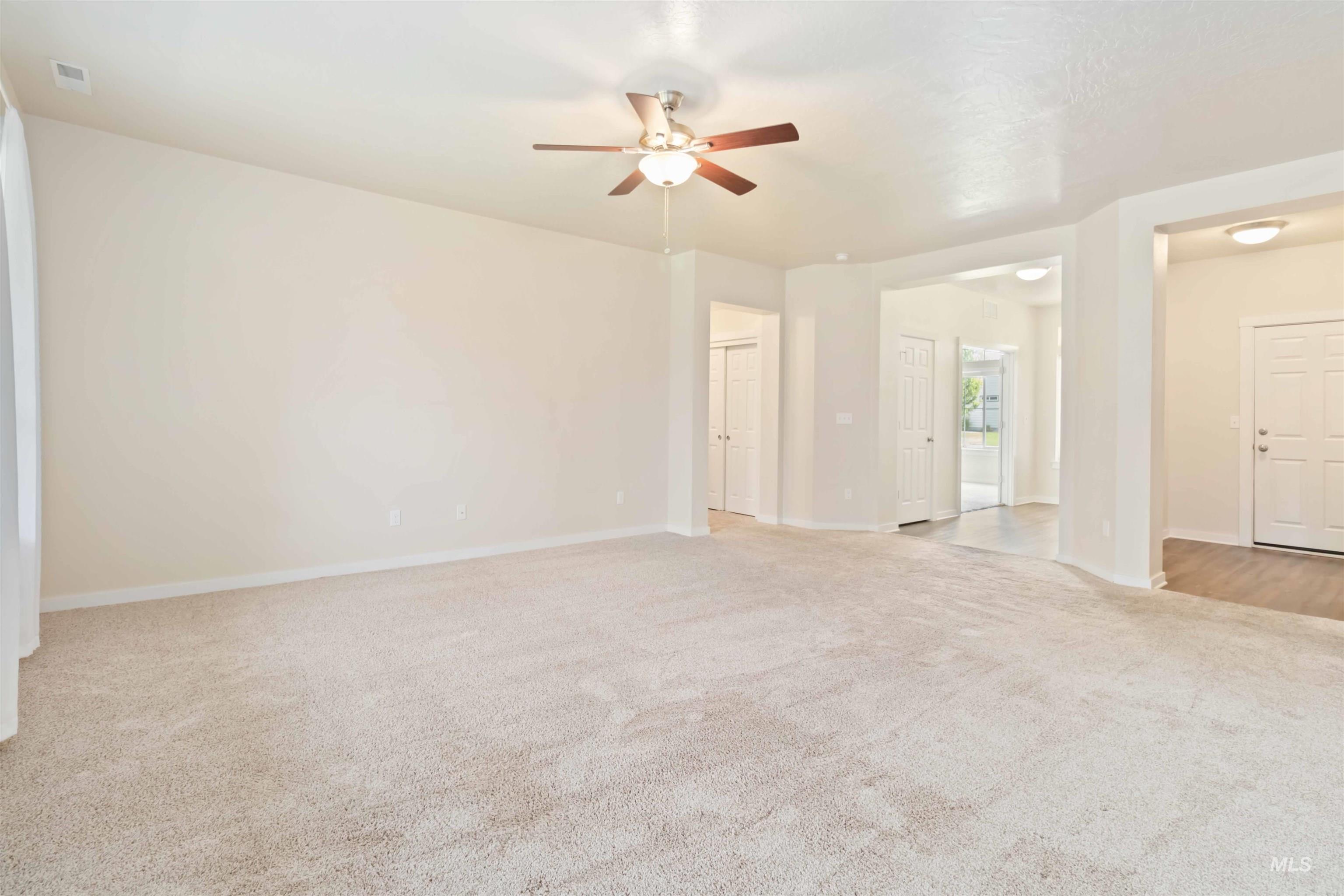 Unfurnished room featuring light carpet and a ceiling fan