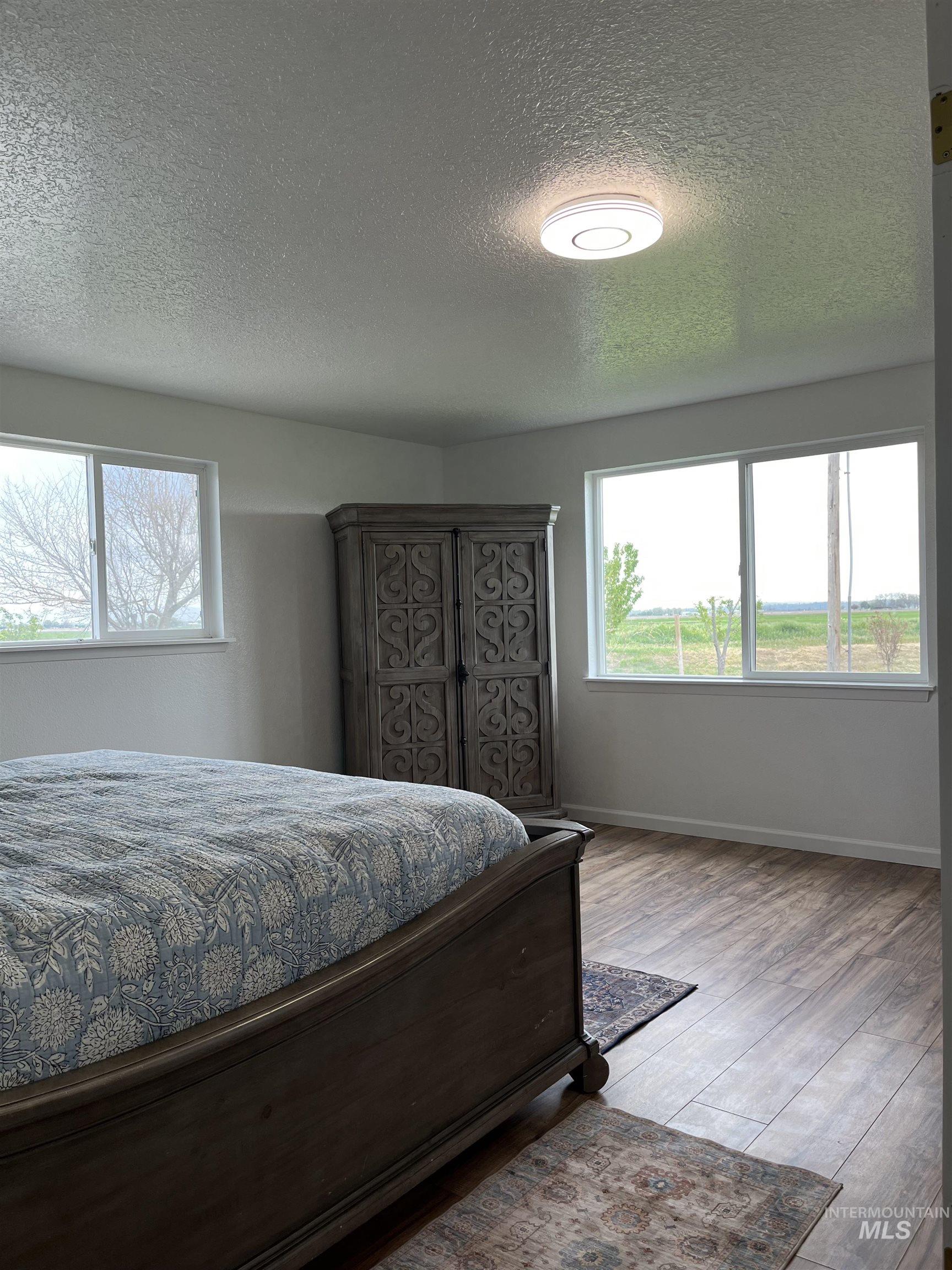 Bedroom featuring a textured ceiling and wood finished floors