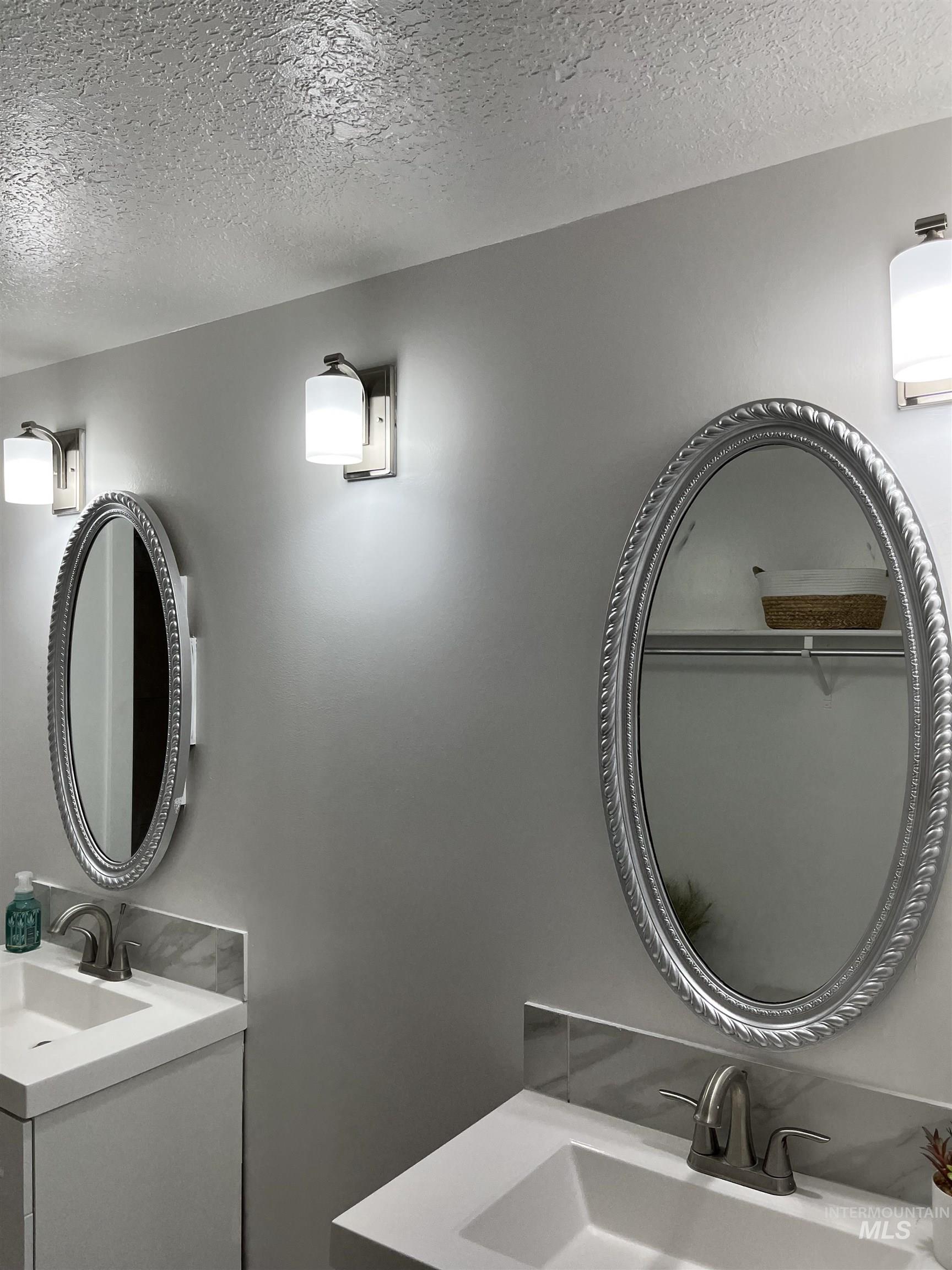 Bathroom featuring a textured ceiling and vanity
