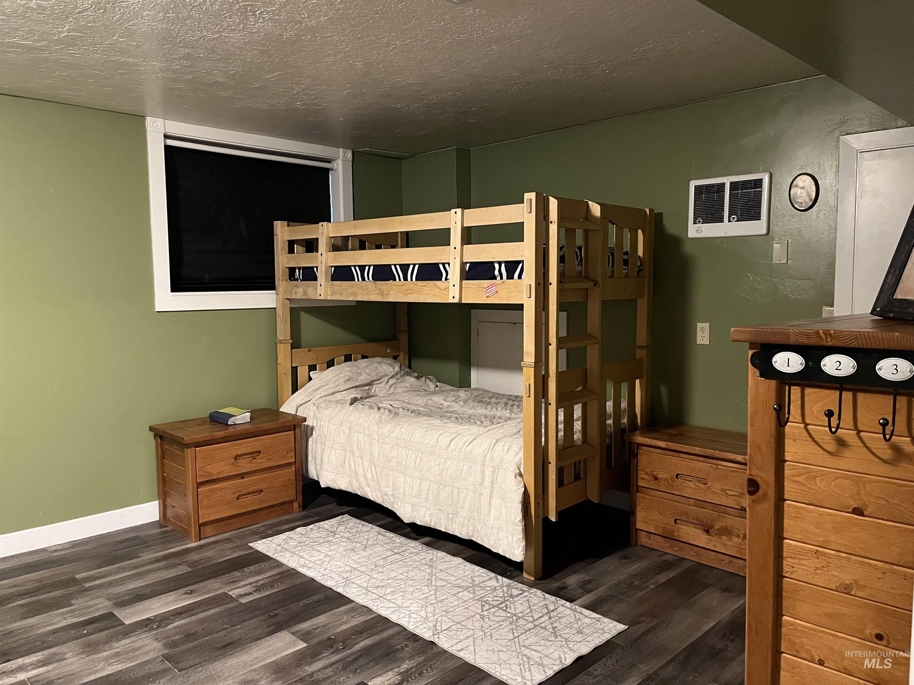 Bedroom featuring a textured ceiling and dark wood finished floors