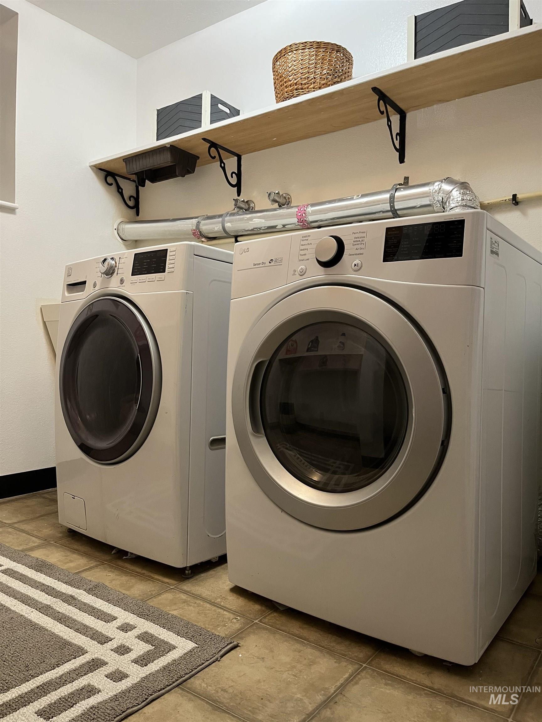 Washroom featuring washer and clothes dryer and baseboards