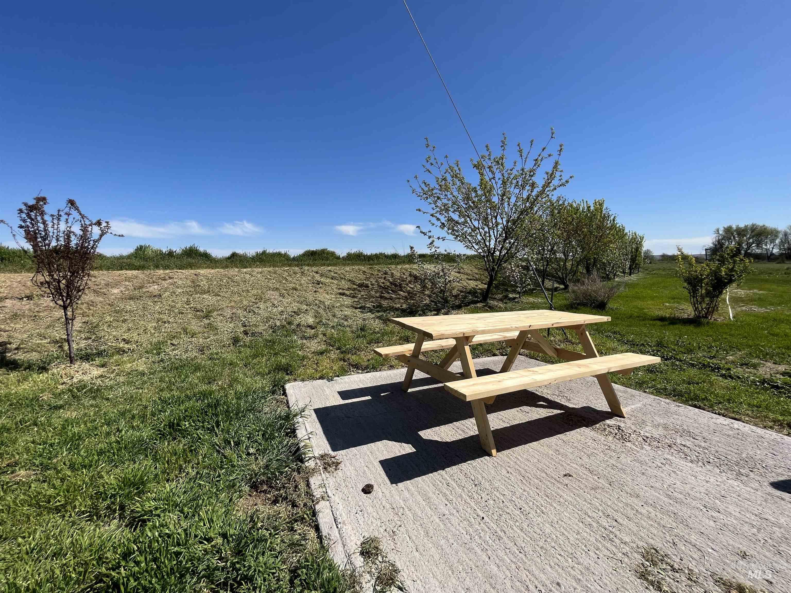 View of home's community featuring a view of rural / pastoral area, a lawn, and outdoor dining area
