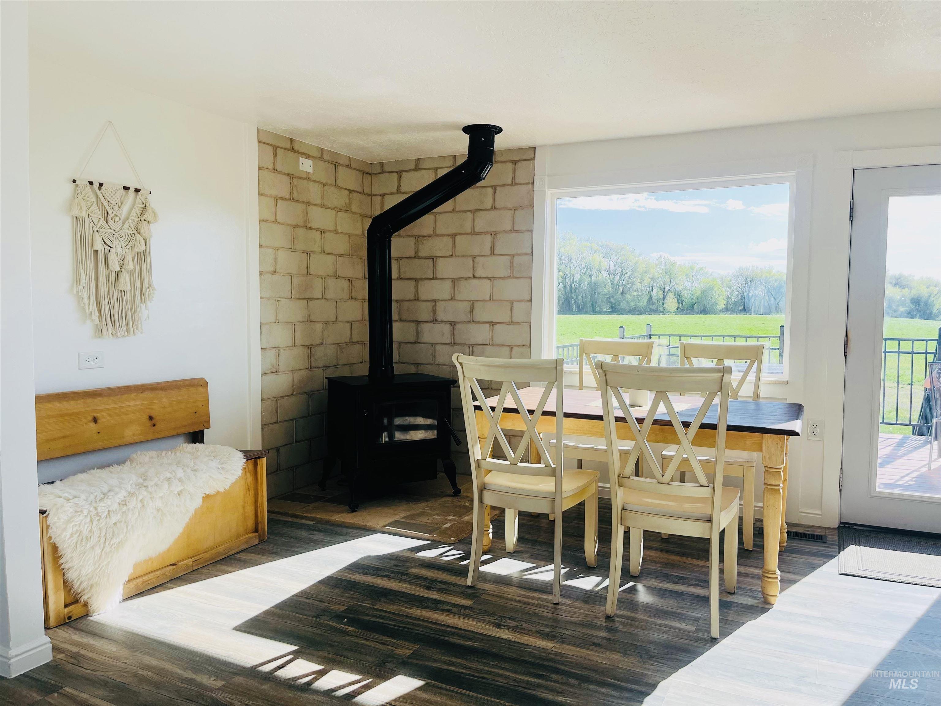 Dining room with a wood stove and dark wood-style flooring