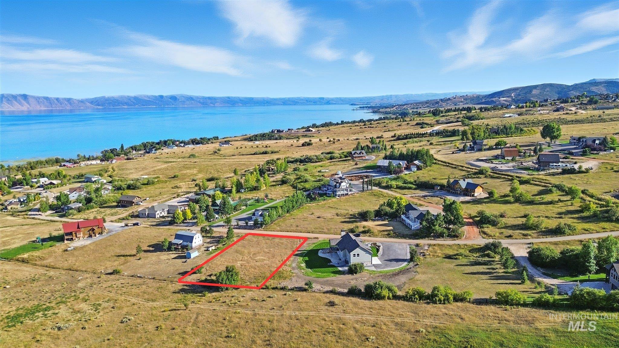 Aerial view of property and surrounding area with property boundaries highlighted and a water and mountain view