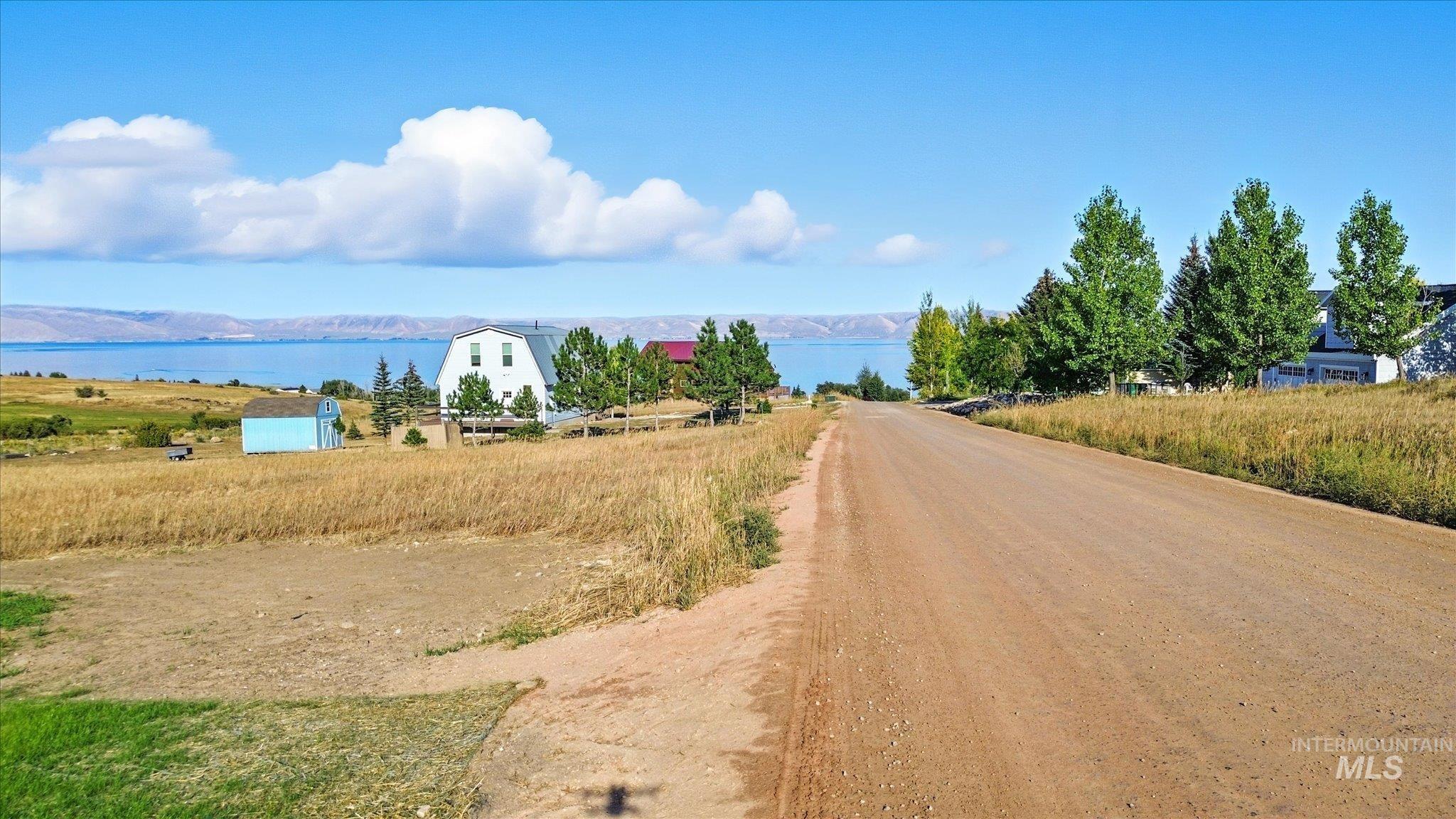 View of dirt / gravel road with a water view