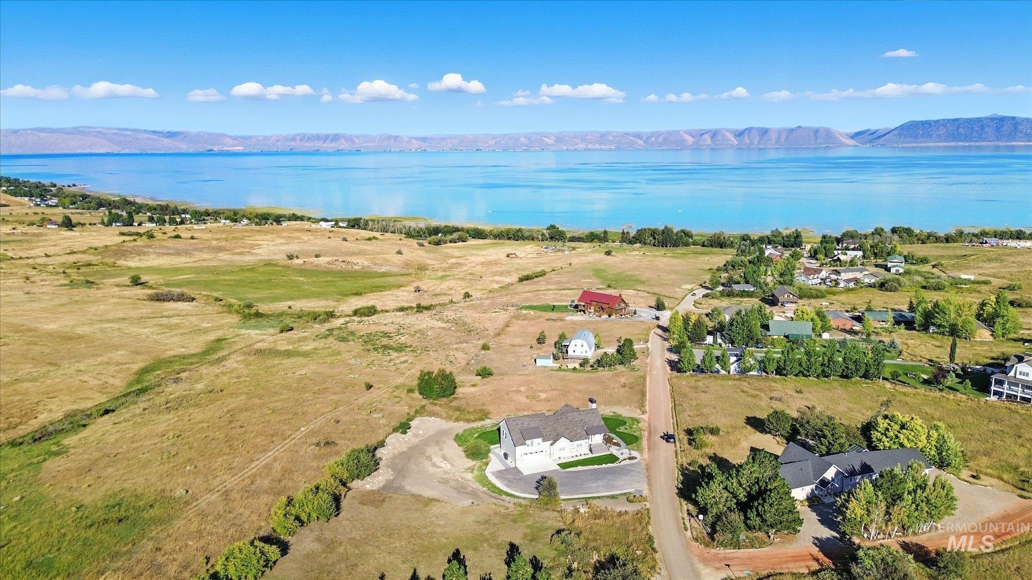 Aerial view of property and surrounding area featuring a water and mountain view