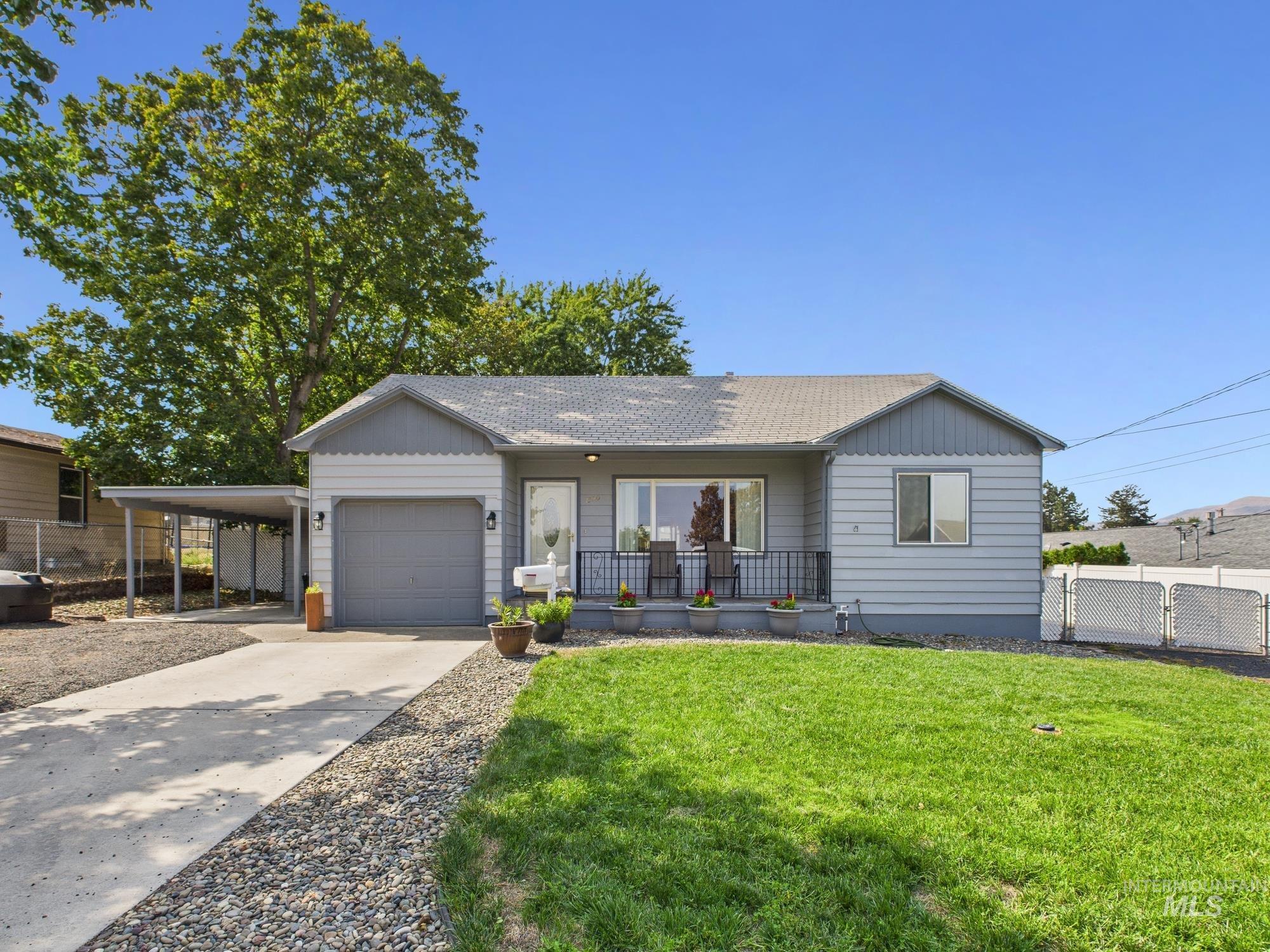 Ranch-style house with covered porch, roof with shingles, driveway, an attached carport, and an attached garage