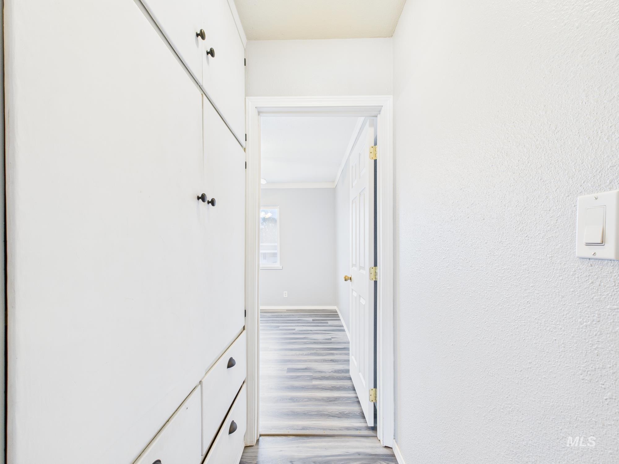 Corridor featuring light wood finished floors and baseboards