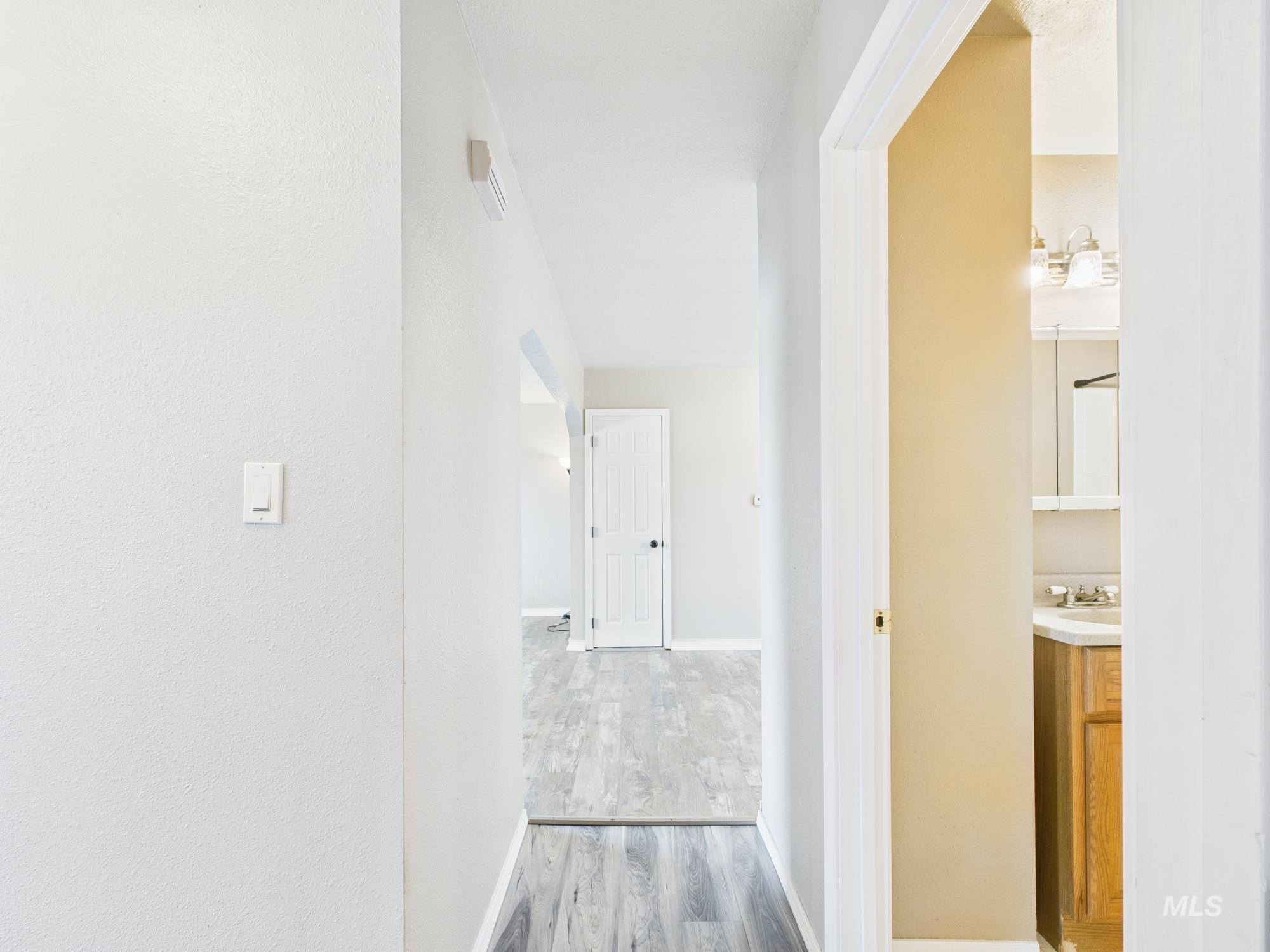 Corridor with wood finished floors and baseboards