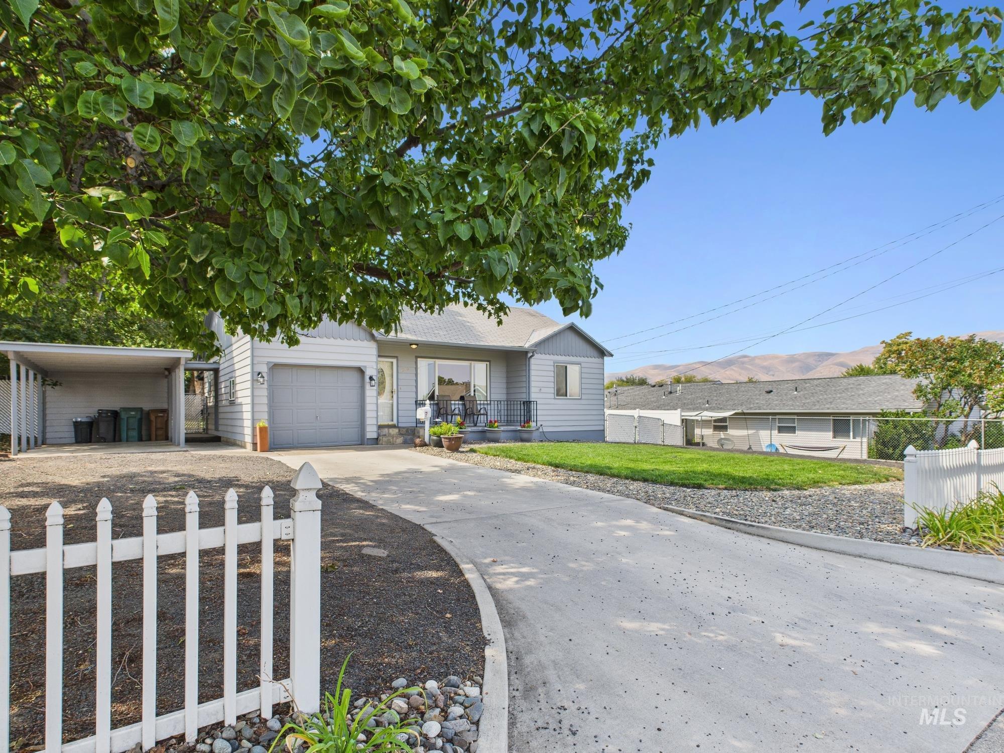 View of front facade with driveway, a patio, and a carport