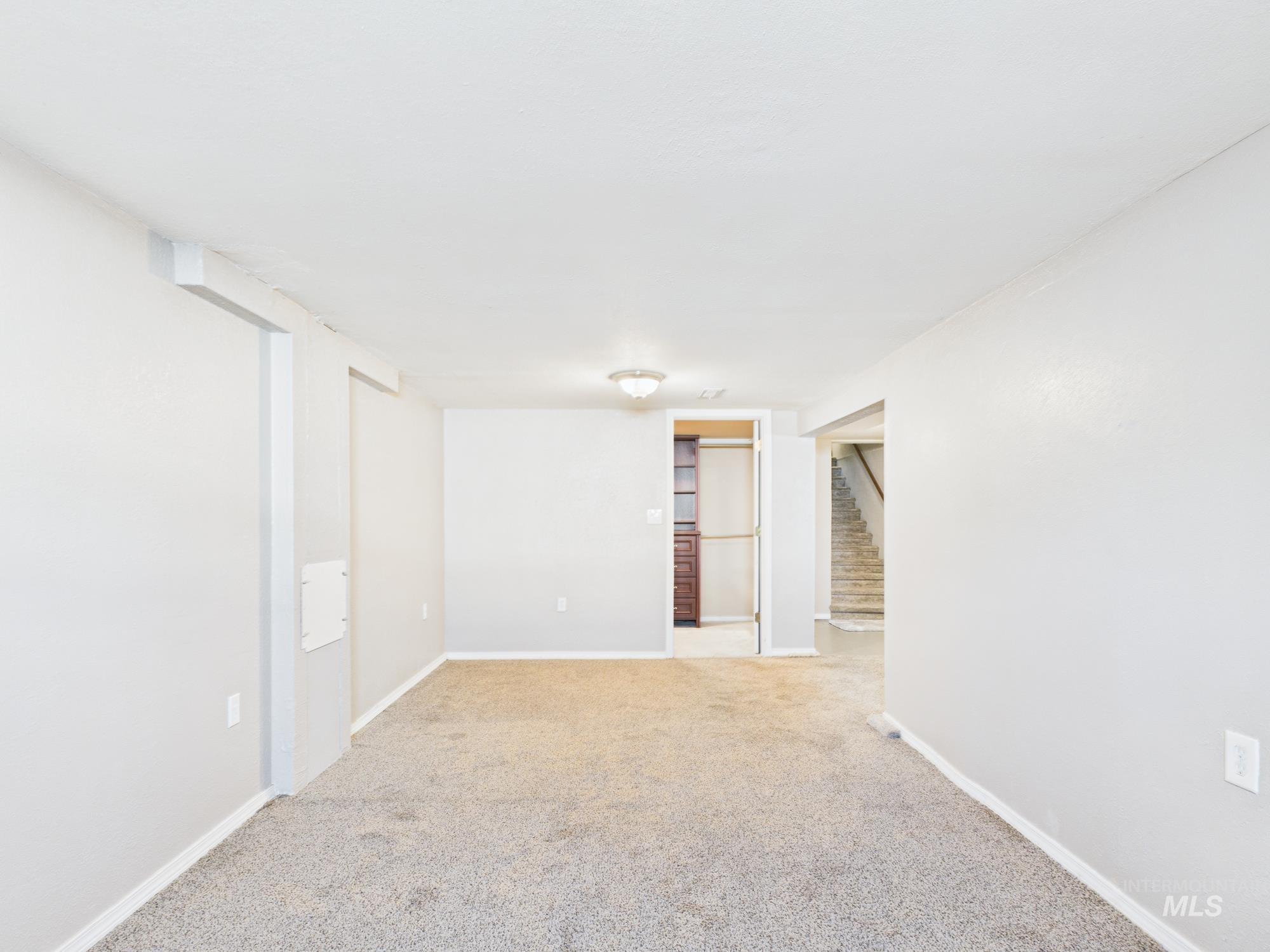 Spare room with carpet flooring and stairs