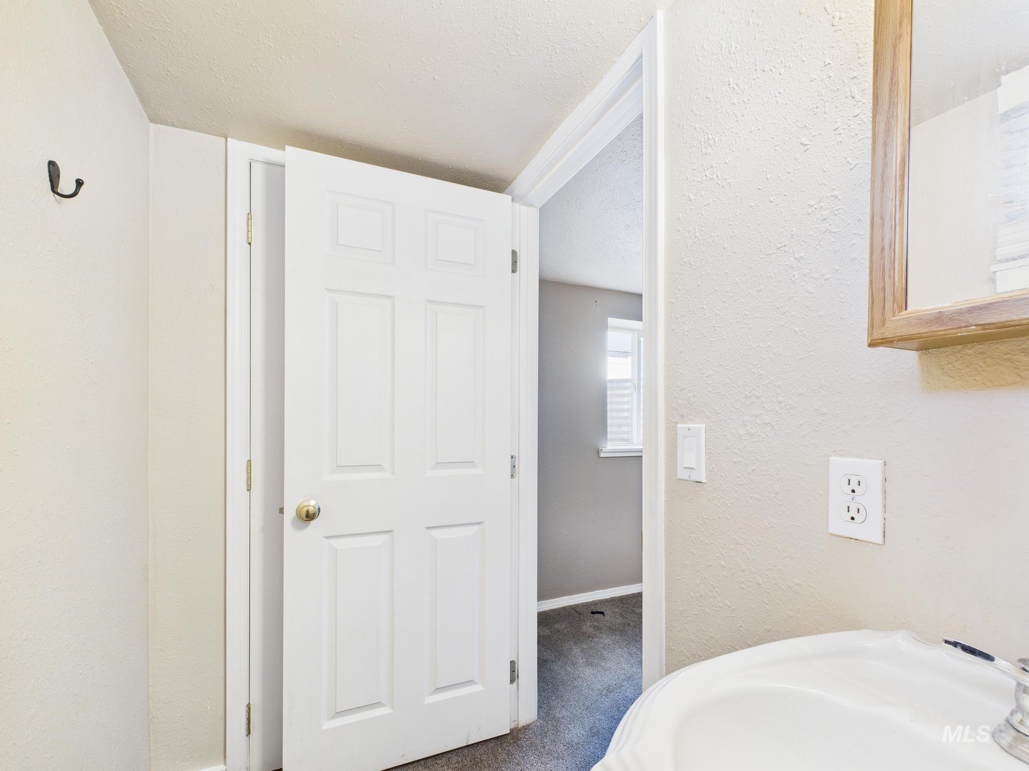 Bathroom featuring a textured ceiling and a textured wall
