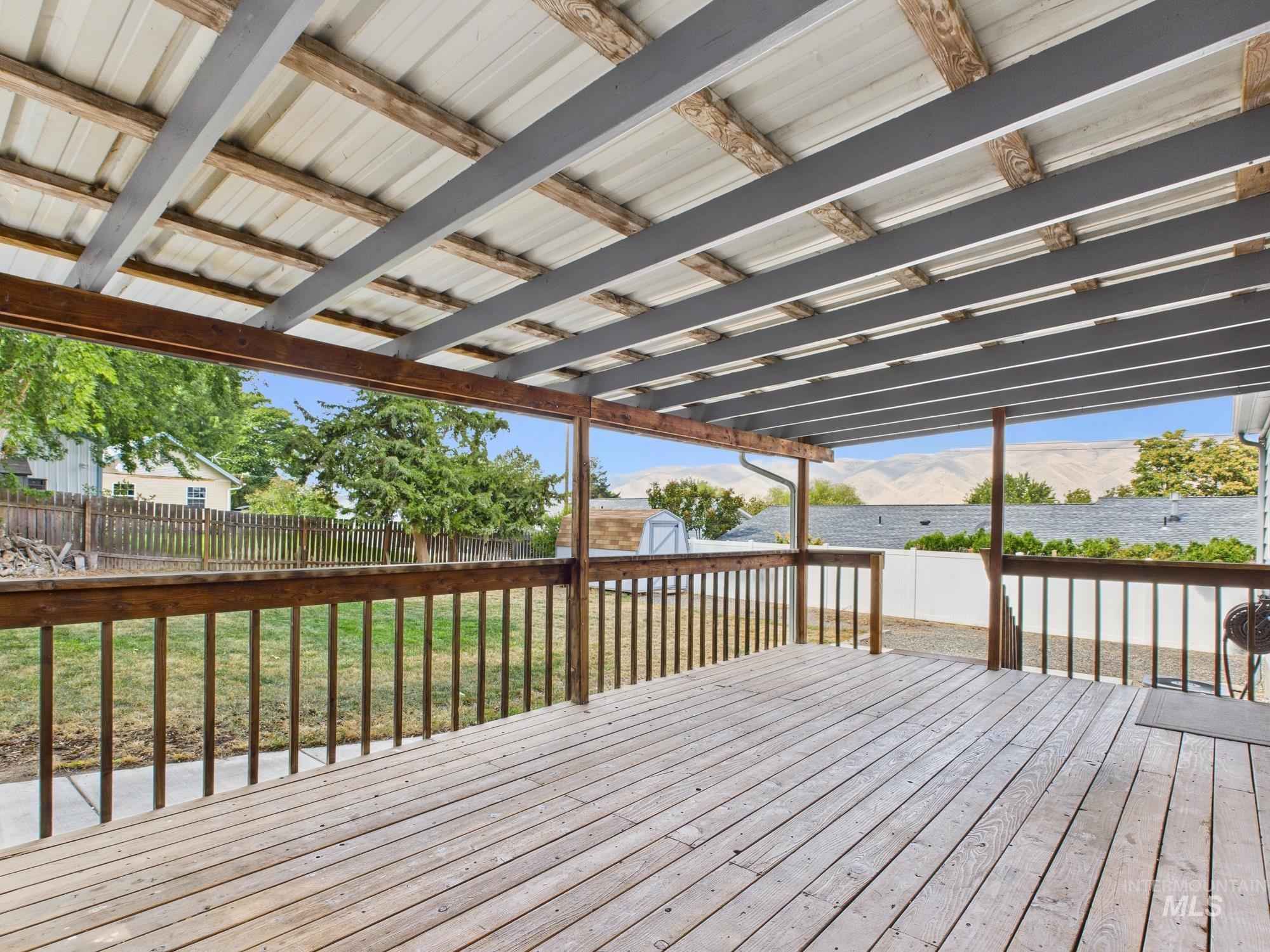 Wooden deck featuring a storage shed, a mountain view, and a fenced backyard