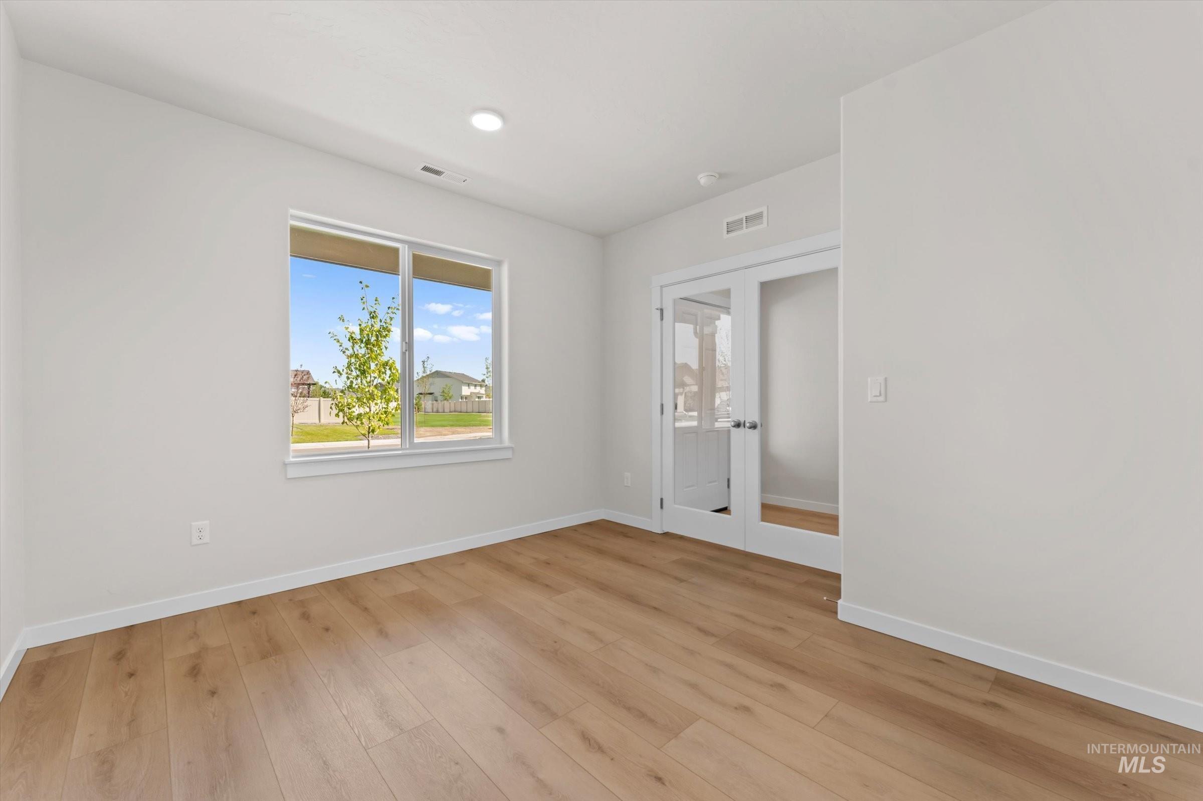 Spare room (office) with french doors, light wood-type flooring, and recessed lighting