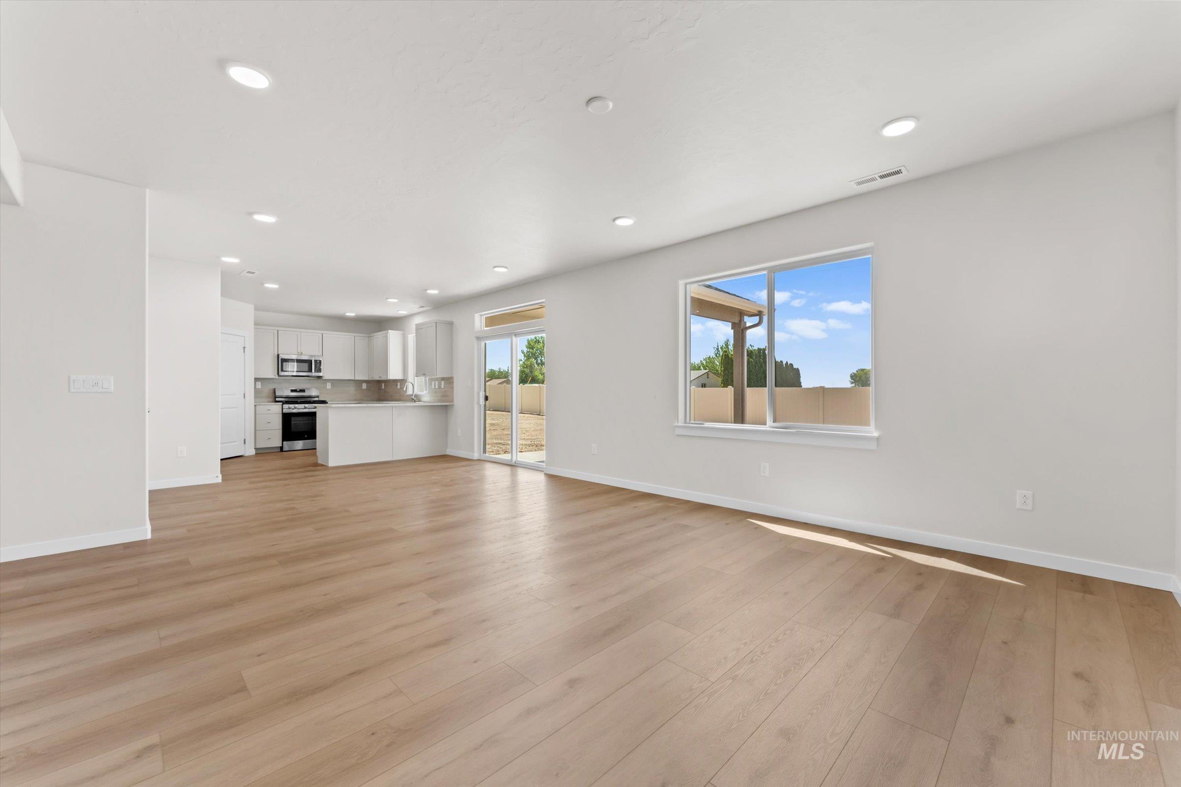 Unfurnished great room with light wood-style floors and recessed lighting