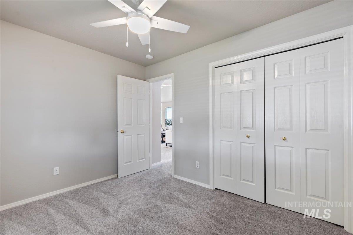 Unfurnished bedroom featuring carpet floors, a closet, and ceiling fan
