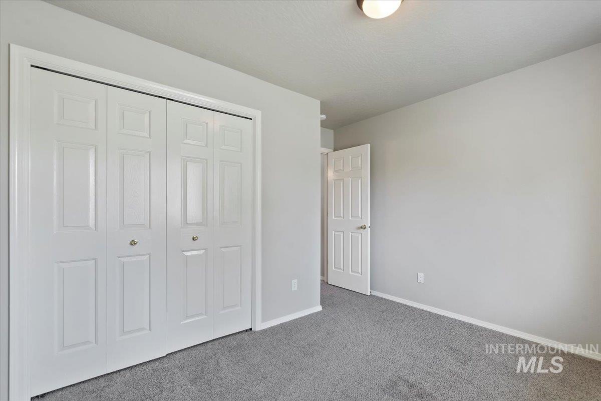Unfurnished bedroom featuring carpet flooring and a closet