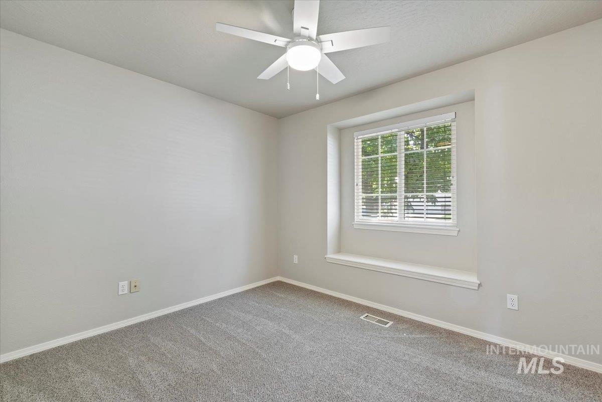 Empty room with carpet flooring and ceiling fan