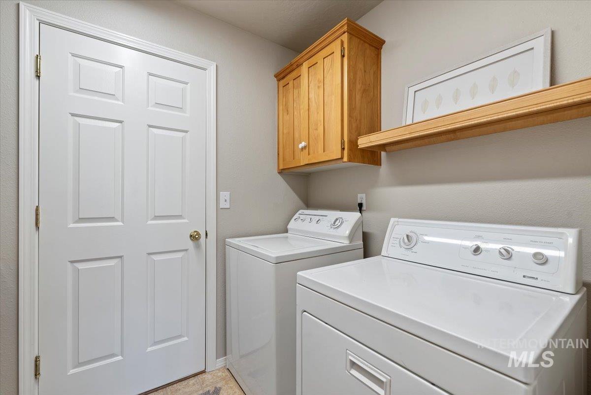 Laundry area featuring washer and clothes dryer and cabinet space