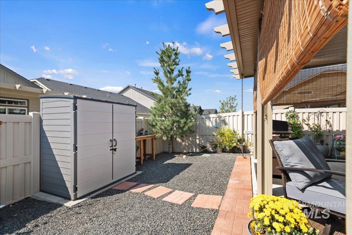 Fenced backyard featuring a patio and an outbuilding