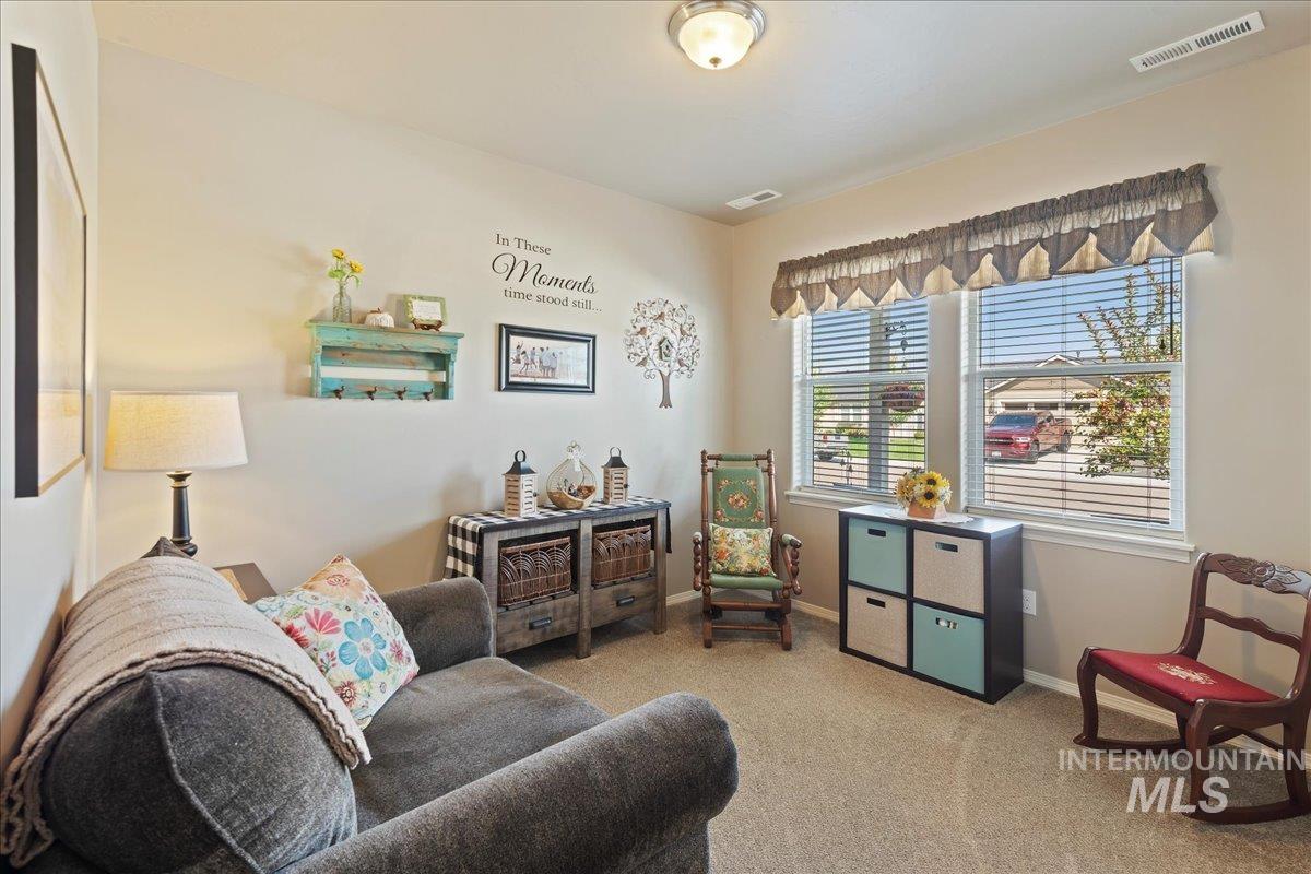 Living area with light colored carpet and baseboards