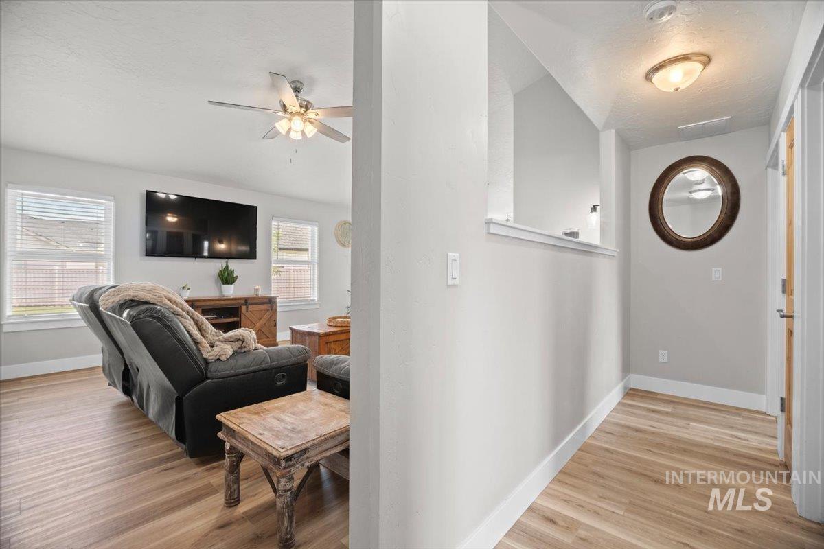 Hall with light wood-style flooring and a textured ceiling