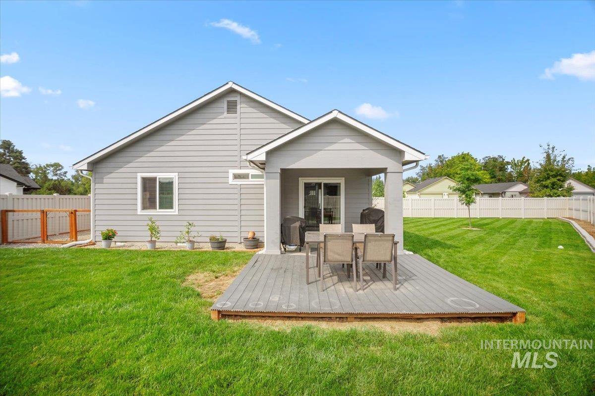 Rear view of property with a fenced backyard, outdoor dining space, a wooden deck, and a patio area