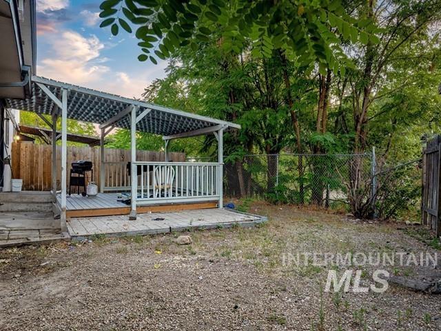 Fenced backyard featuring a deck