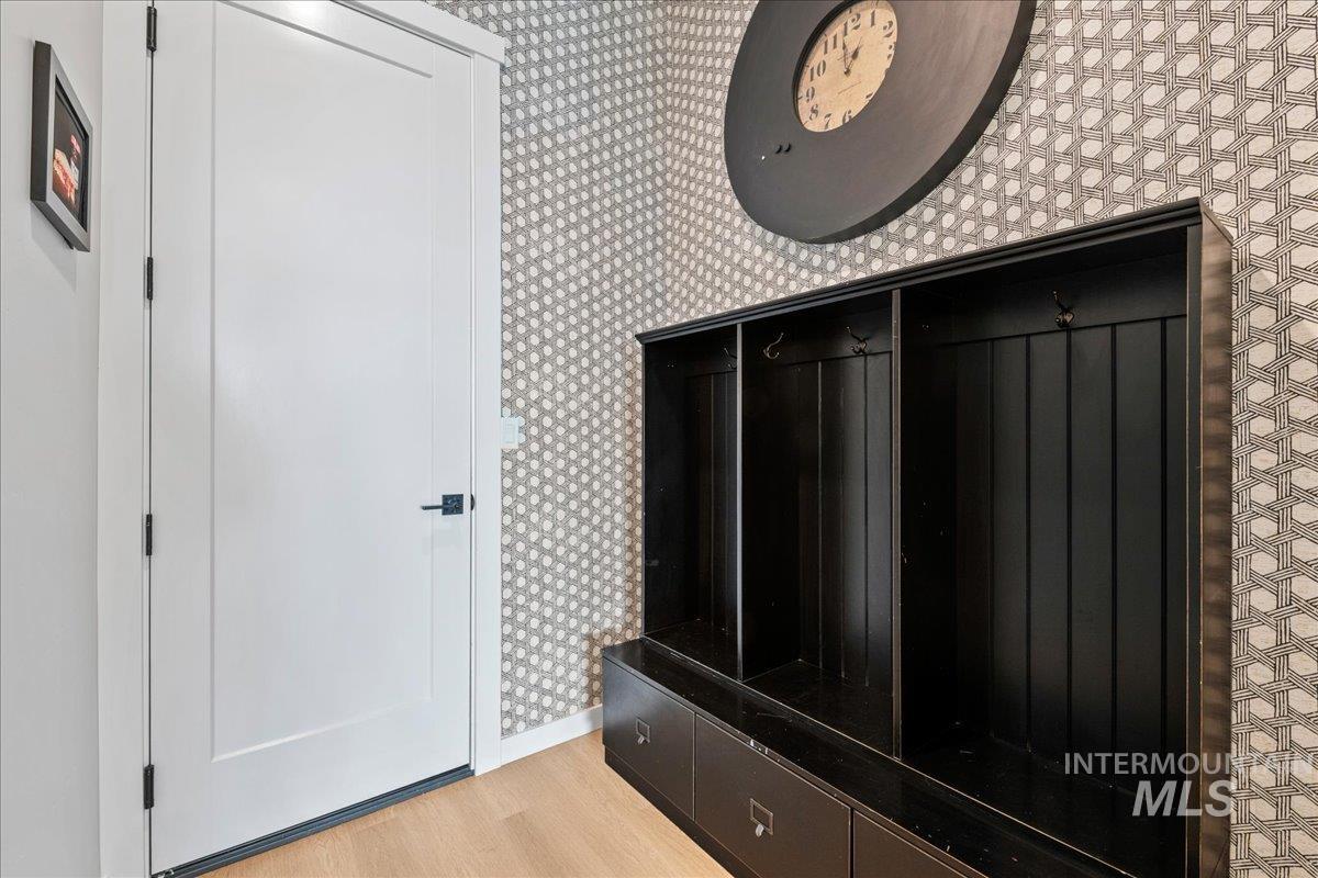 Mudroom with wallpapered walls and light wood-style flooring