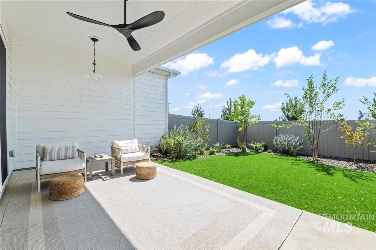 Fenced backyard featuring a patio and ceiling fan
