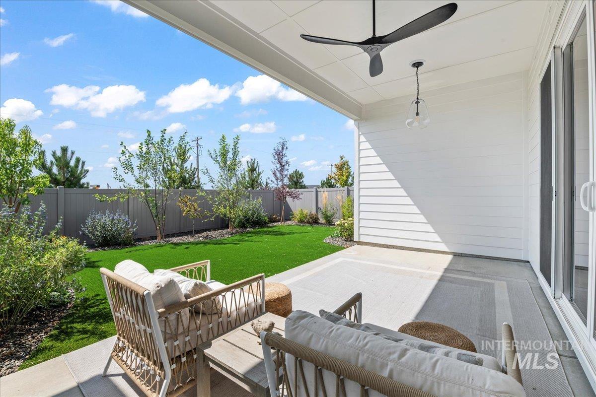 Fenced backyard featuring a patio area, an outdoor living space, and a ceiling fan