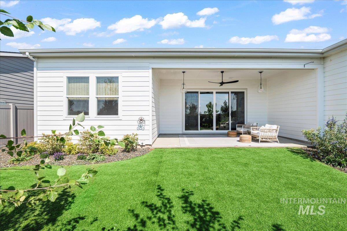 Back of house with a patio, a ceiling fan, and a yard