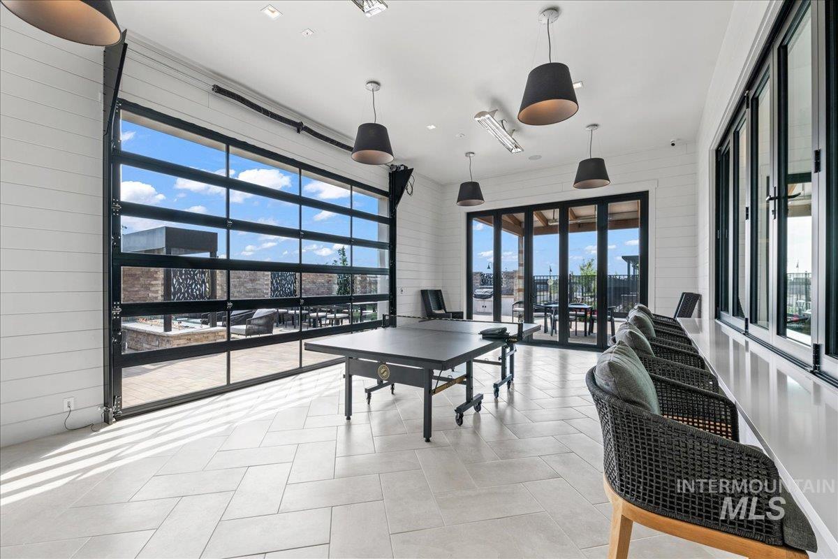 Game room featuring wooden walls and light tile patterned floors