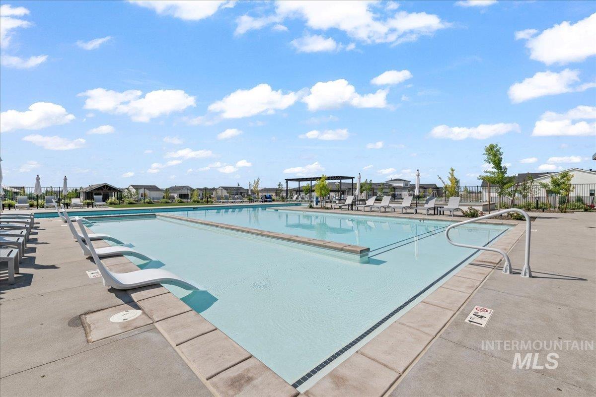 Community pool with a patio area and a residential view