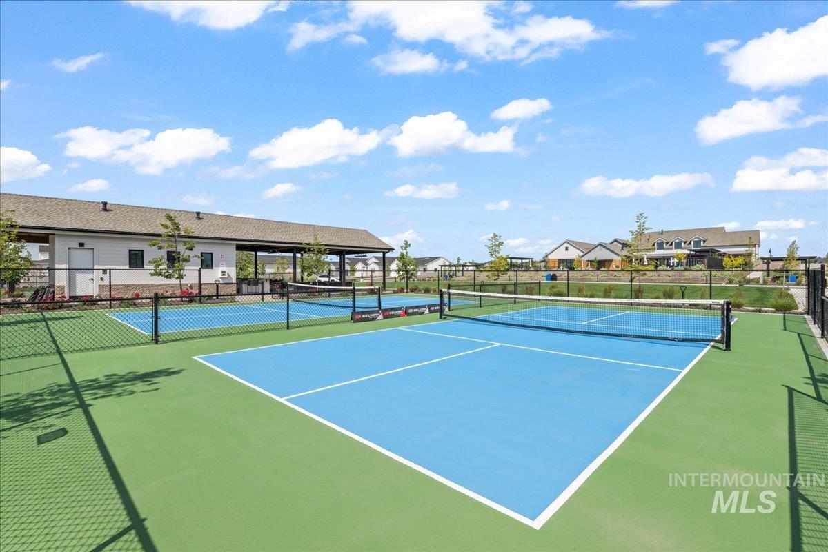 View of tennis court featuring a residential view