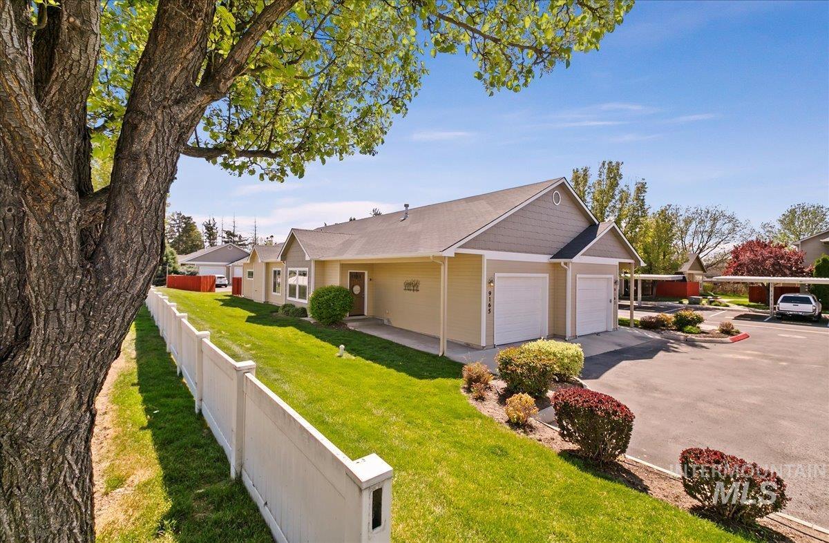 View of side of property featuring driveway and an attached garage and the manicured common area that is maintained by the HOA!