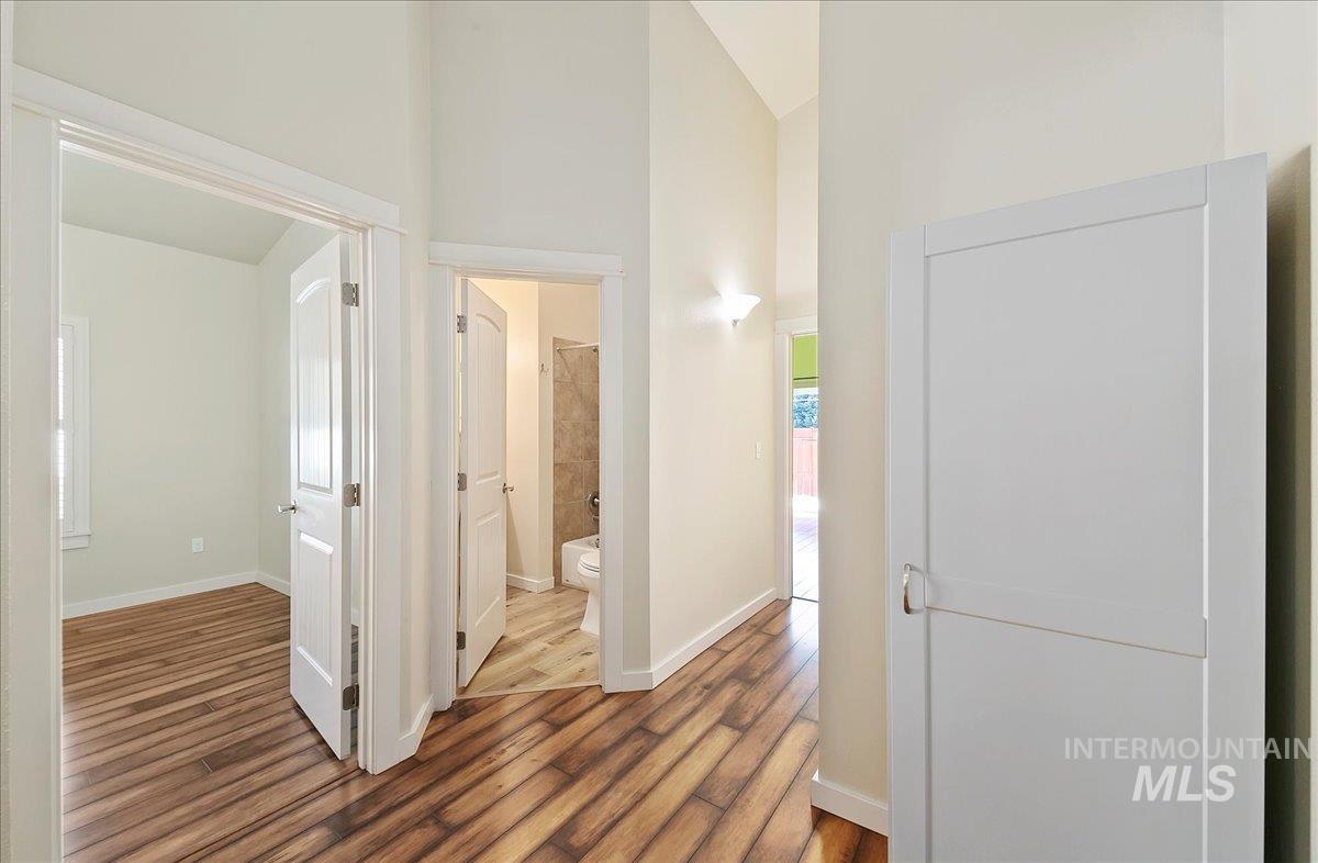 Corridor featuring laminate floors and high vaulted ceiling.  Sooo Easy to Clean!