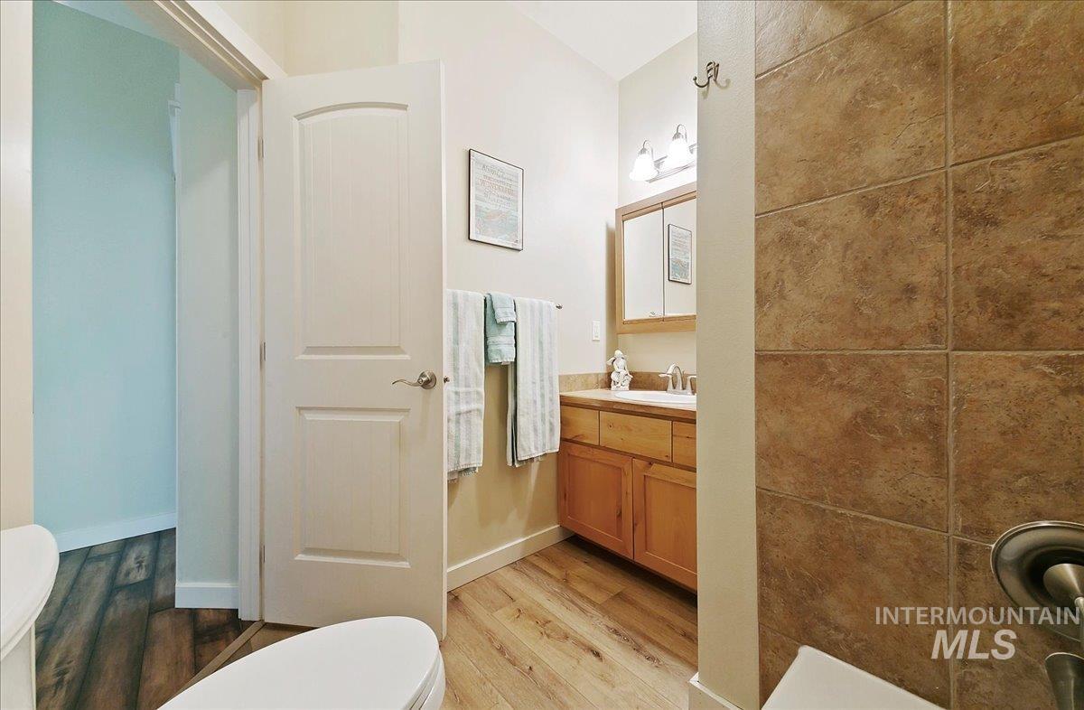 Full bathroom featuring vanity and light wood-style laminate floors