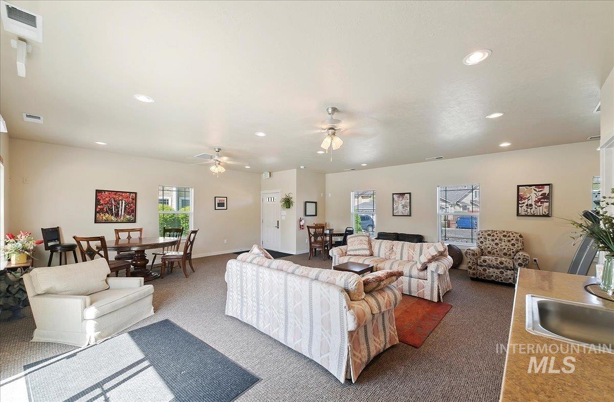 Carpeted living area featuring recessed lighting, plenty of natural light, and ceiling fan, cozy & comfortable furniture, card/craft table - let's have a party!