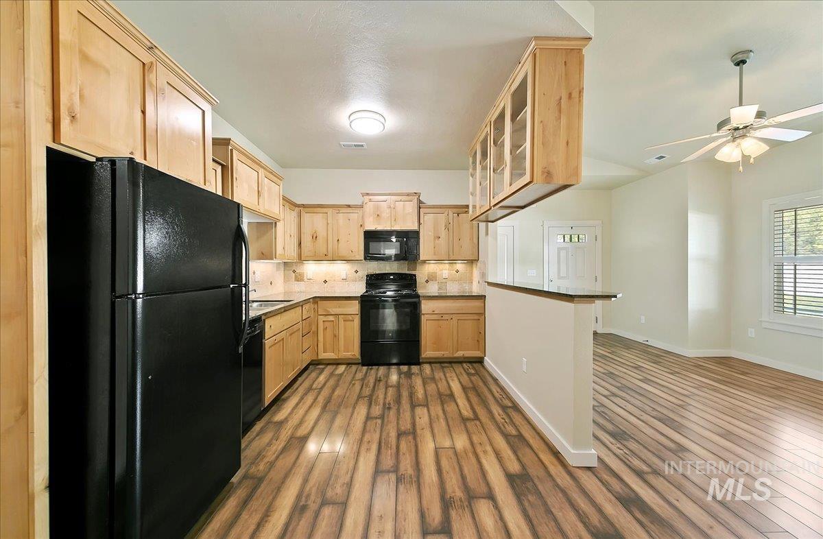 Kitchen featuring black appliances, Full Tile Backsplash, Granite Countertops, Laminate Wood Look Flooring!