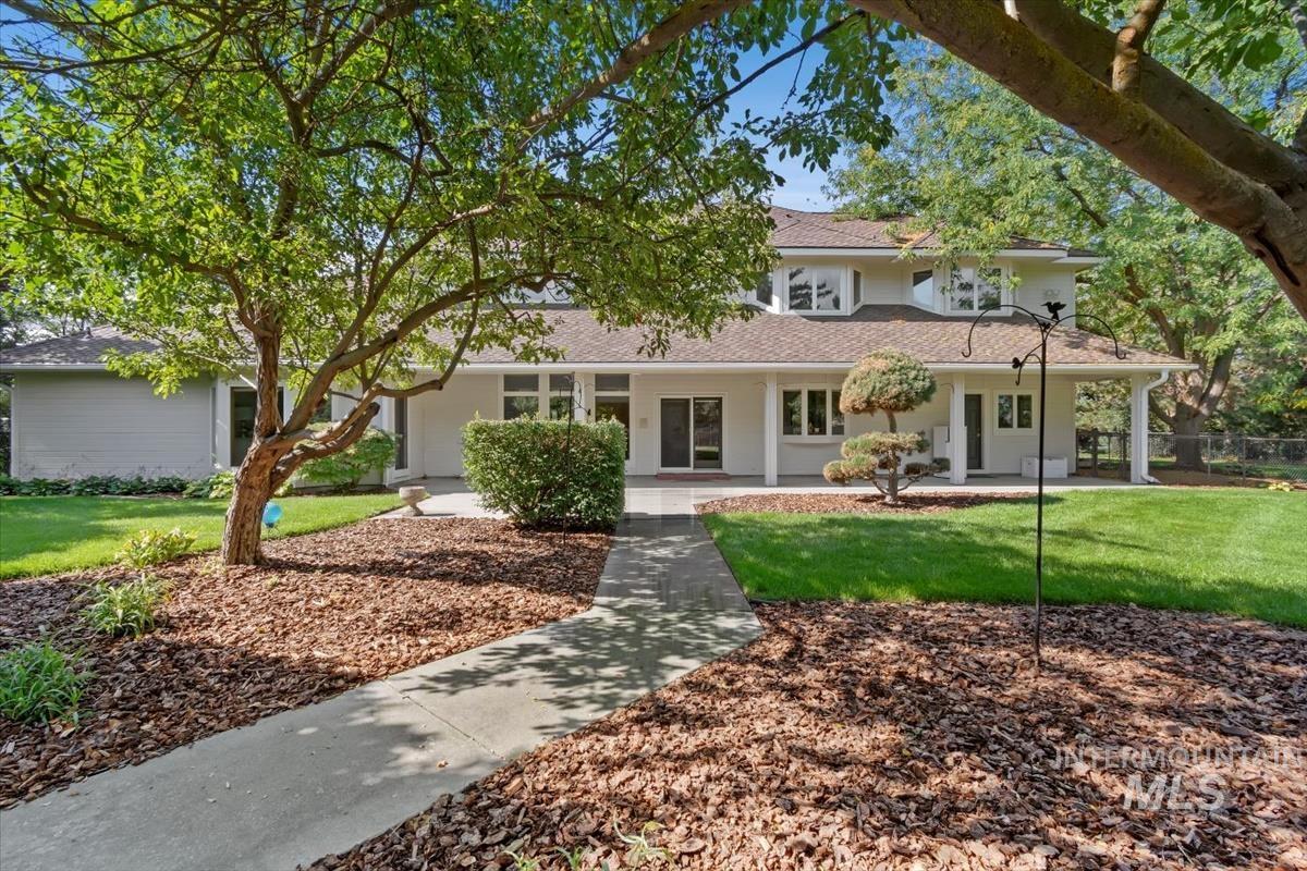 View of front of property with a front yard, roof with shingles, and a porch