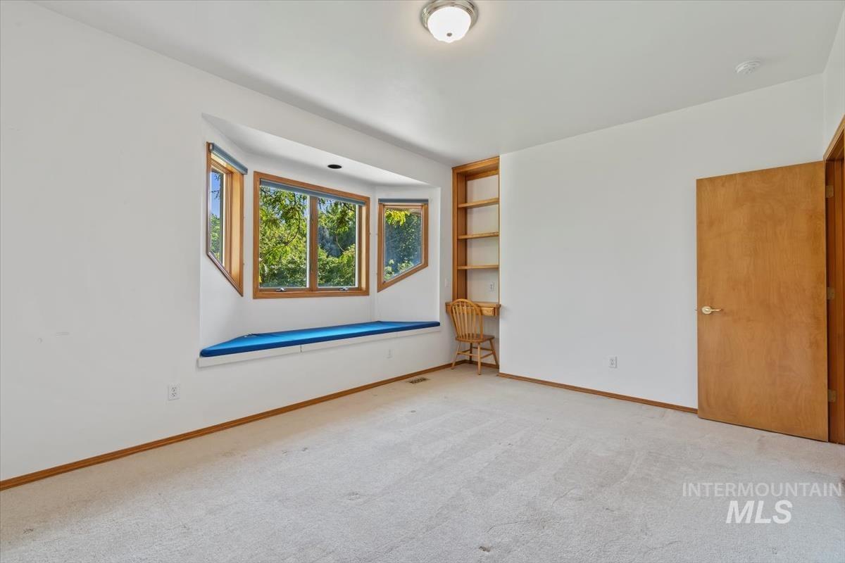 Empty room featuring light carpet and baseboards