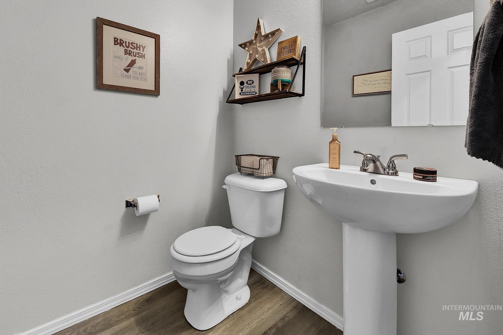 Bathroom with a textured wall and dark wood finished floors