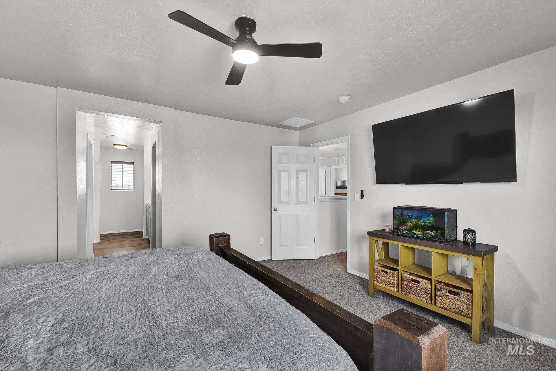 Carpeted bedroom featuring baseboards and ceiling fan