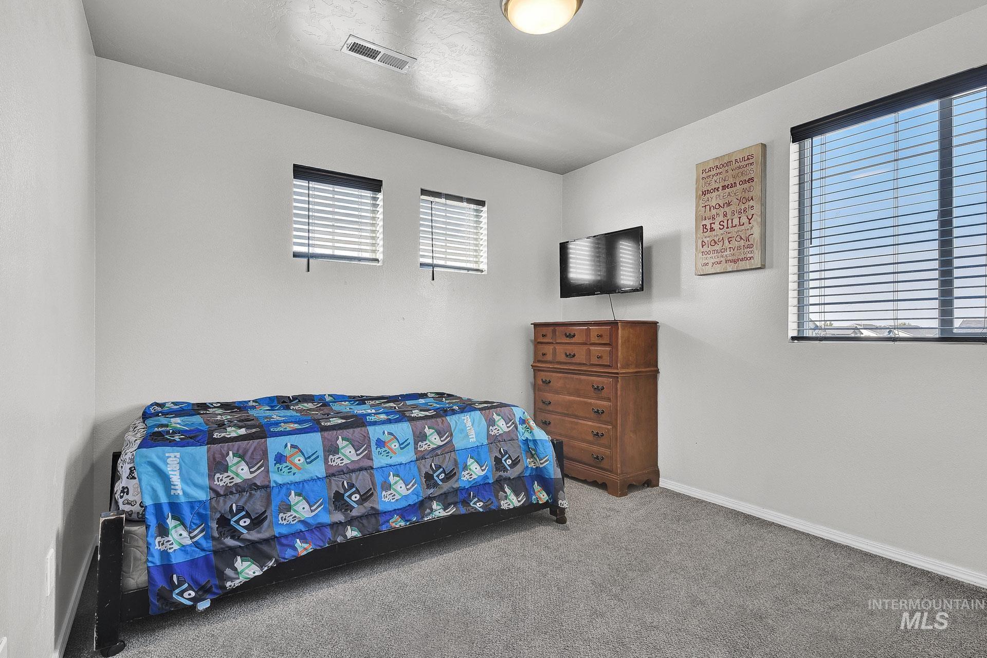 Carpeted bedroom with multiple windows