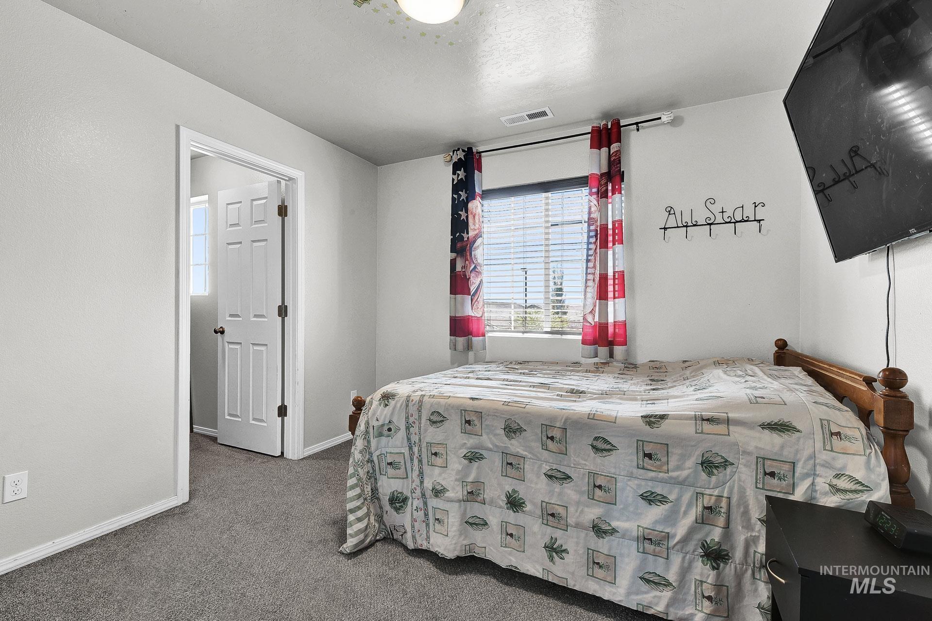 Carpeted bedroom with baseboards and a textured ceiling
