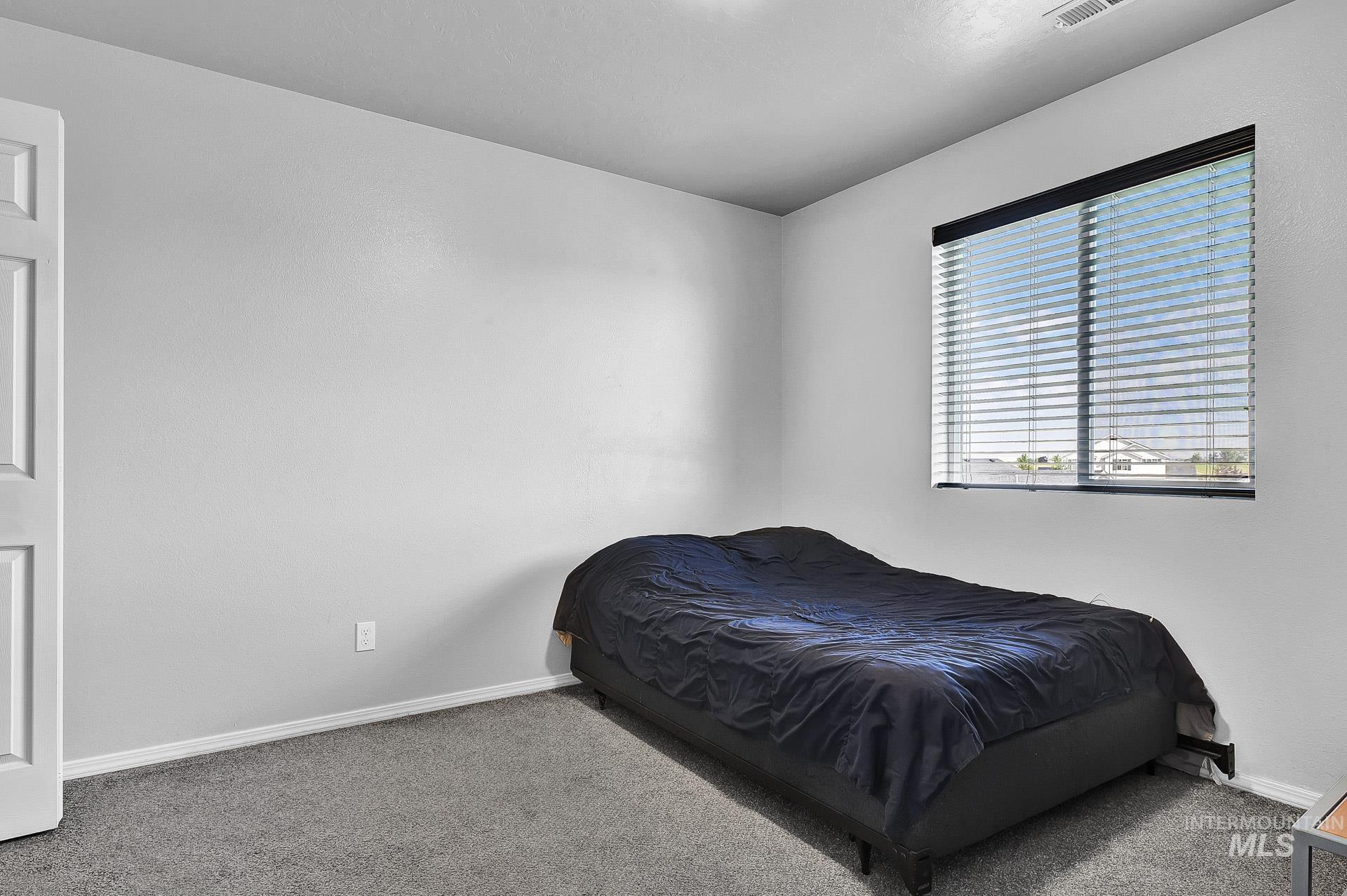 Bedroom featuring carpet floors and baseboards