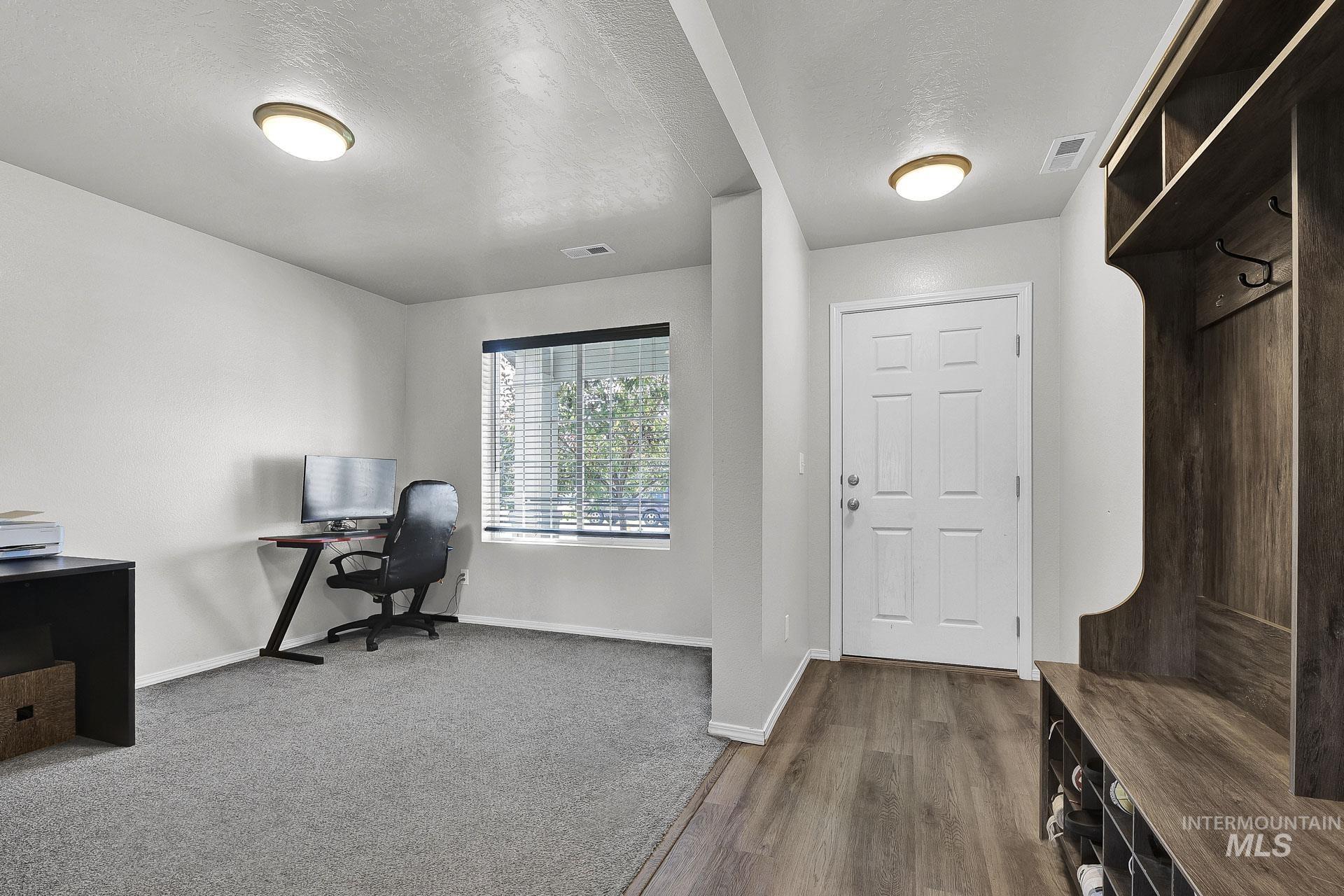 Home office with a textured ceiling and dark wood finished floors