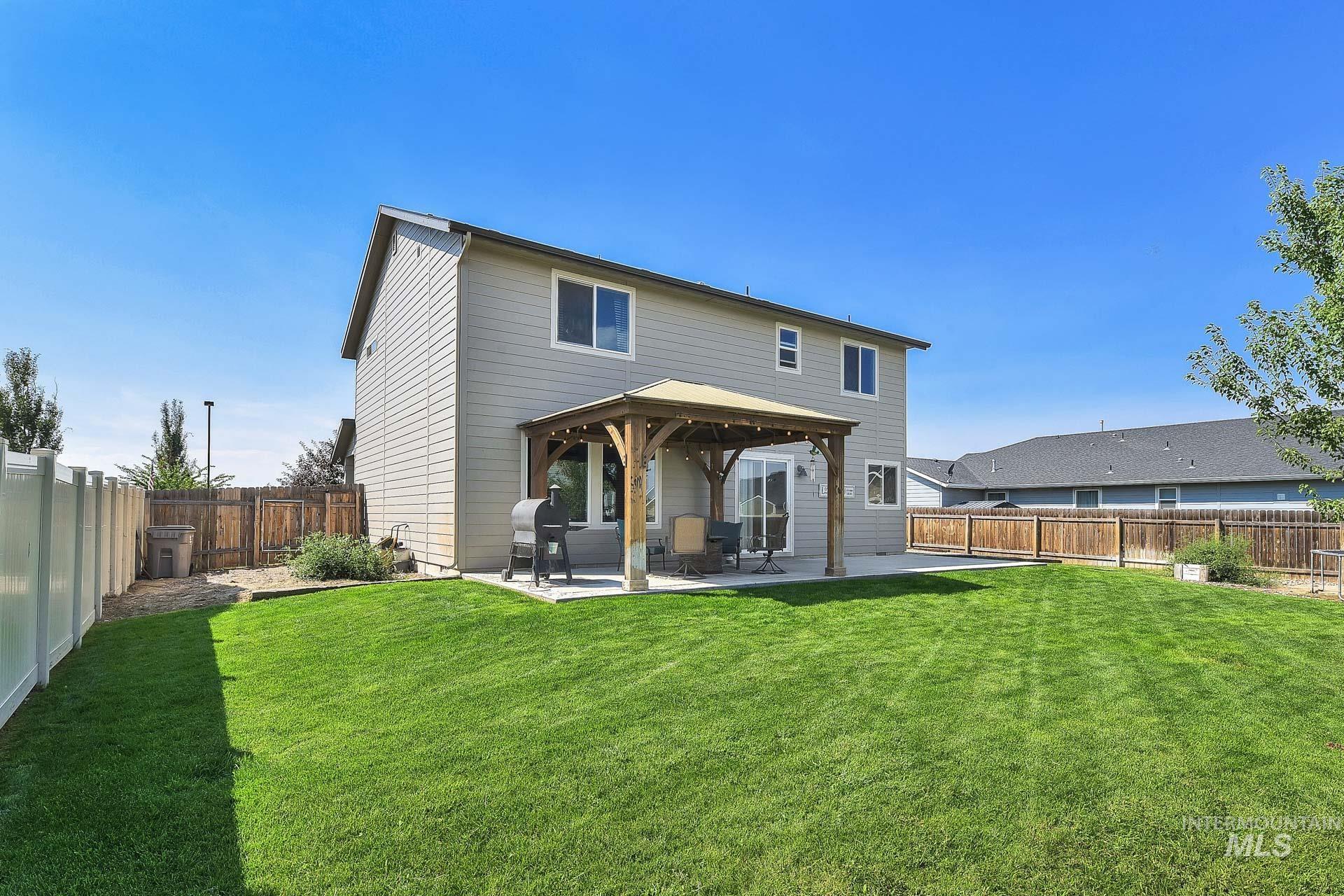 Rear view of house featuring a patio area and a fenced backyard